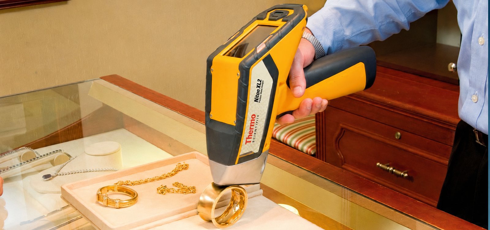 Analizador Thermo Scientific Niton XL2 de espectrometría XRF midiendo la pureza de una joya de oro